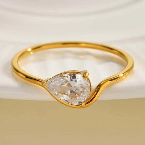 Feiner gewellter Ring mit weißem Kristall in Tropfenform