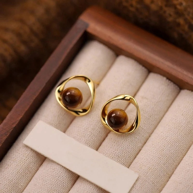 Boucles d'oreilles ondulées dorées et perles effet oeil de tigre