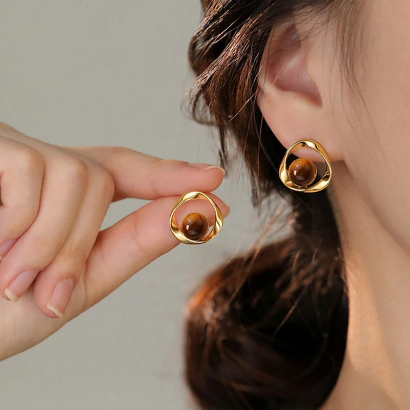 Boucles d'oreilles ondulées dorées et perles effet oeil de tigre