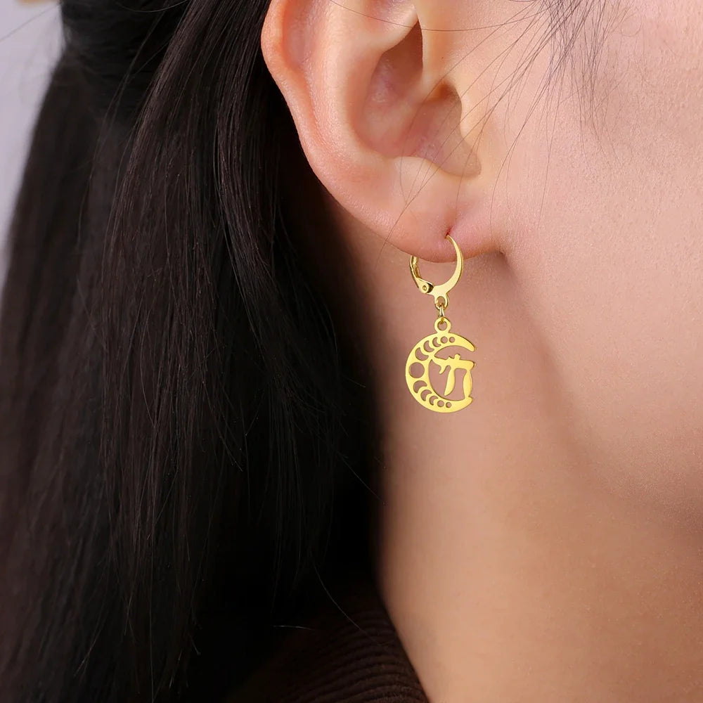 Dangling earrings with the Chai life symbol on a gold crescent moon