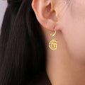 Dangling earrings with the Chai life symbol on a gold crescent moon