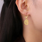 Dangling earrings with the Chai life symbol on a gold crescent moon