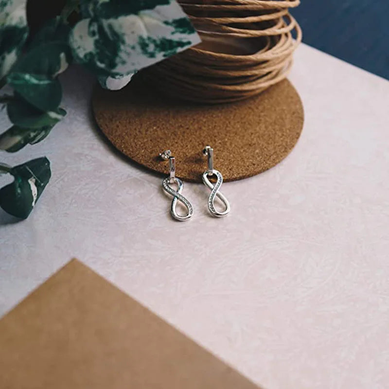 Boucles d'oreilles pendantes symbole infini orné de strass