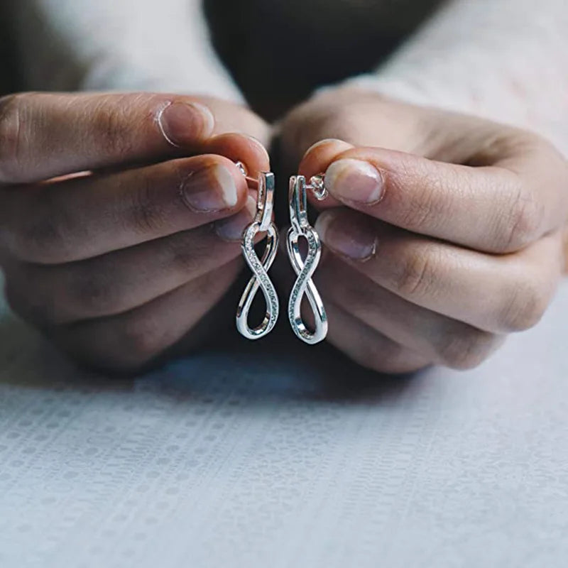 Boucles d'oreilles pendantes symbole infini orné de strass