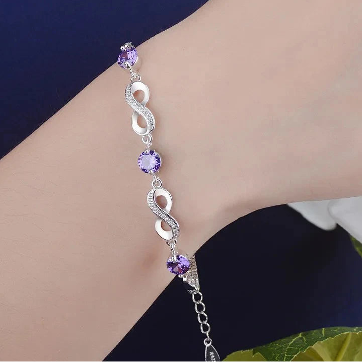 Bracelet avec perles violettes et symboles infinis ornés de cristaux 