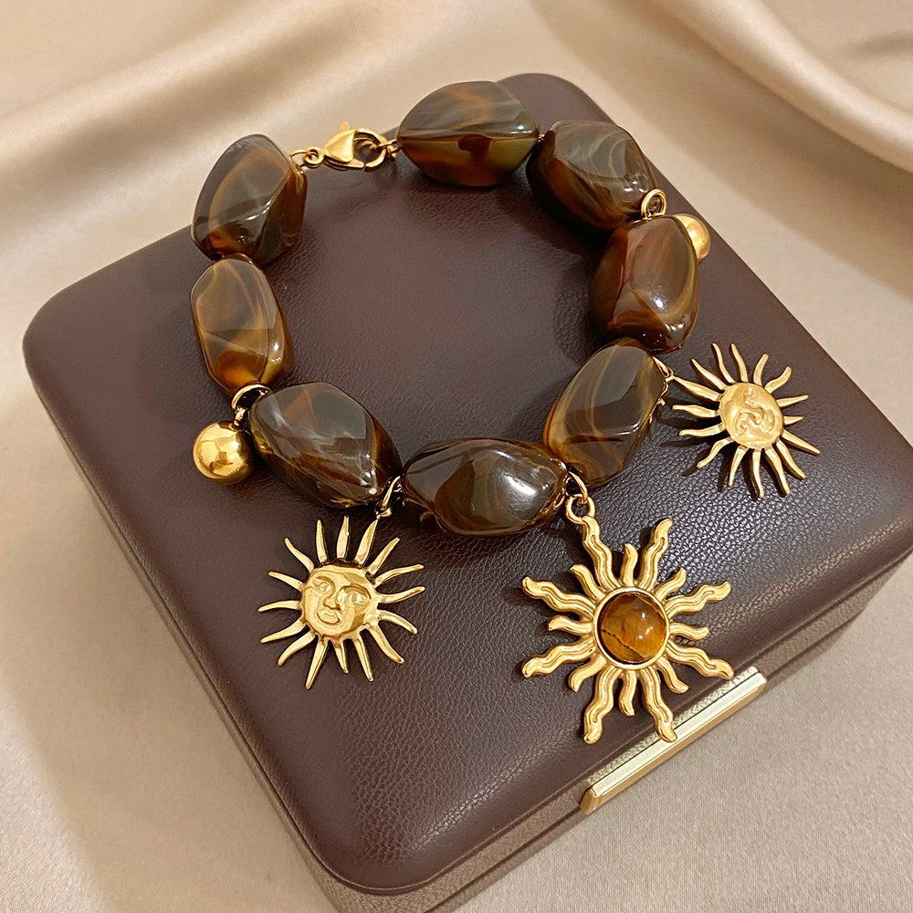 Bracelet bohème avec galets et pendentifs soleils effet oeil de tigre