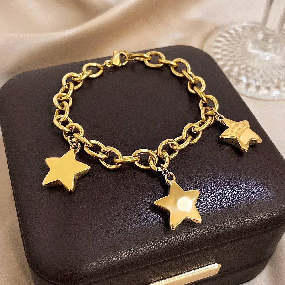 Armbånd med tre hængende stjerner i guld