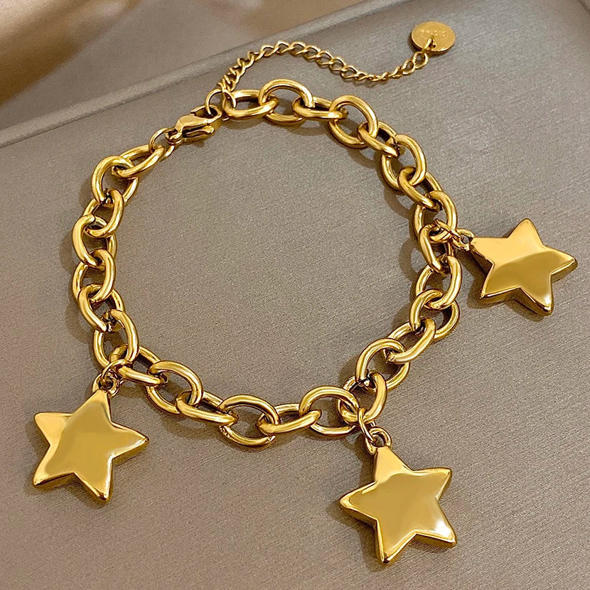 Armbånd med tre hængende stjerner i guld