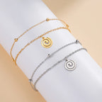 Forgyldt armbånd med lille spiralvedhæng i guld