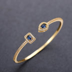 Pulseira aberta pavé de strass e pedra de cristal em forma de gota de água dourado e azul