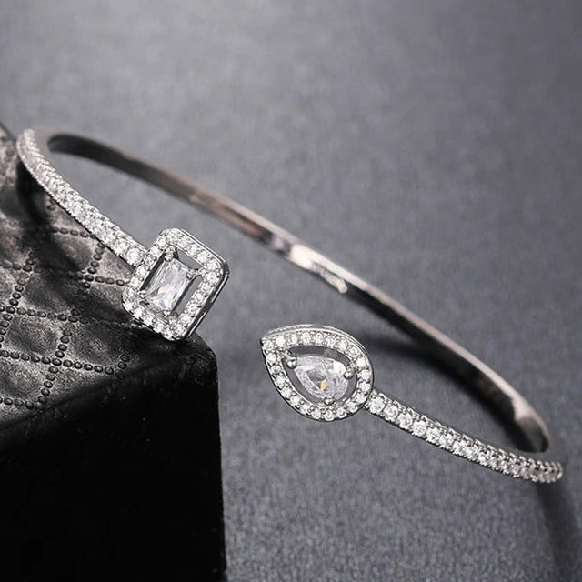 Pulseira aberta pavé de strass e pedra de cristal em forma de gota de água prateado e branco