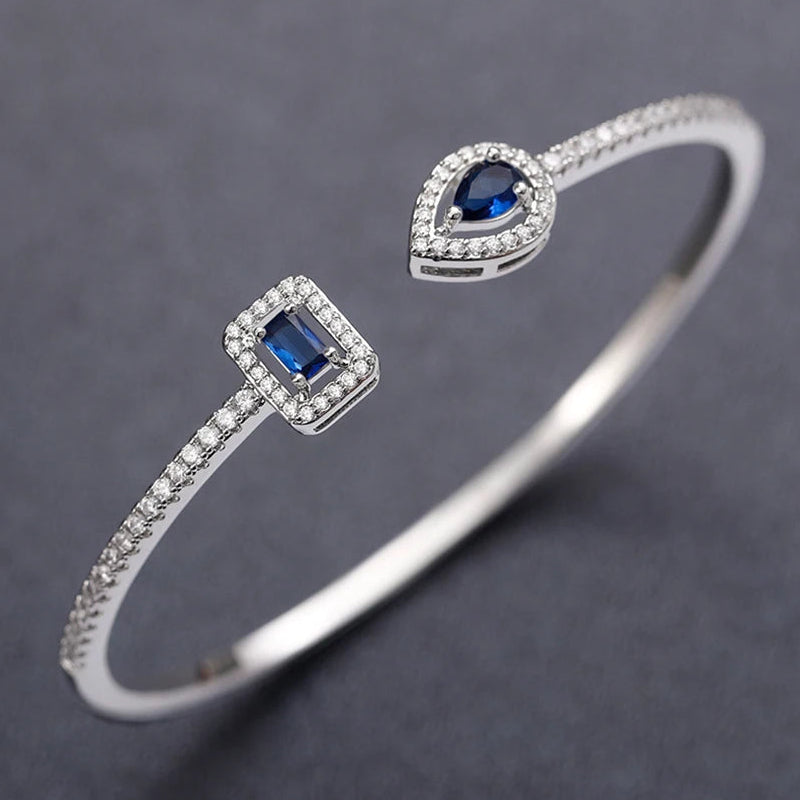 Pulseira aberta pavé de strass e pedra de cristal em forma de gota de água prateado e azul
