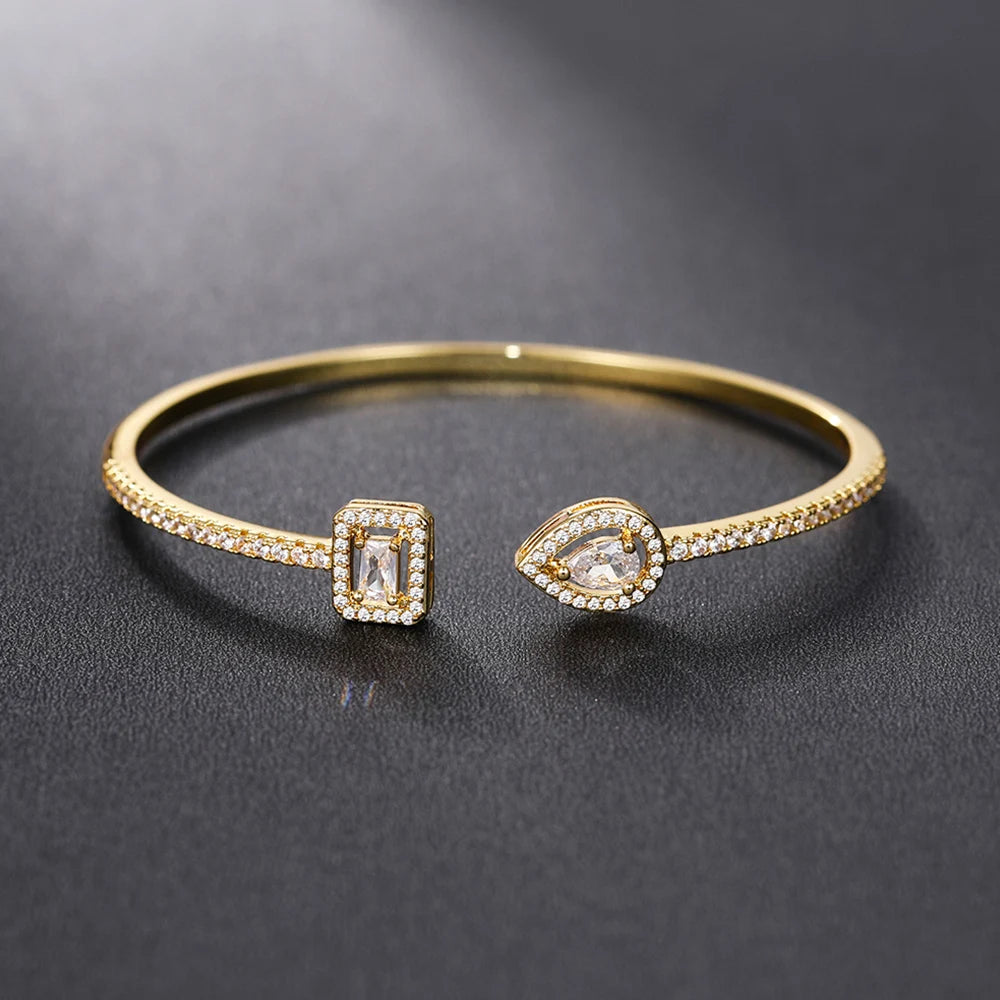 Pulseira aberta pavé de strass e pedra de cristal em forma de gota de água dourado e branco
