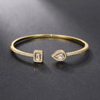 Pulseira aberta pavé de strass e pedra de cristal em forma de gota de água dourado e branco