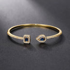 Pulseira aberta pavé de strass e pedra de cristal em forma de gota de água dourado e azul