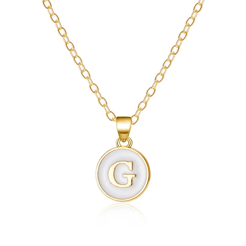 Halsband med vit hängsmycke initial g