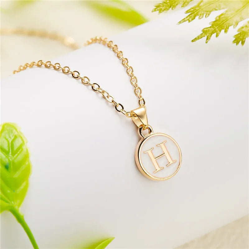 Halsband med vit hängsmycke initial h