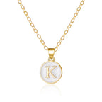 Halsband med vit hängsmycke initial k