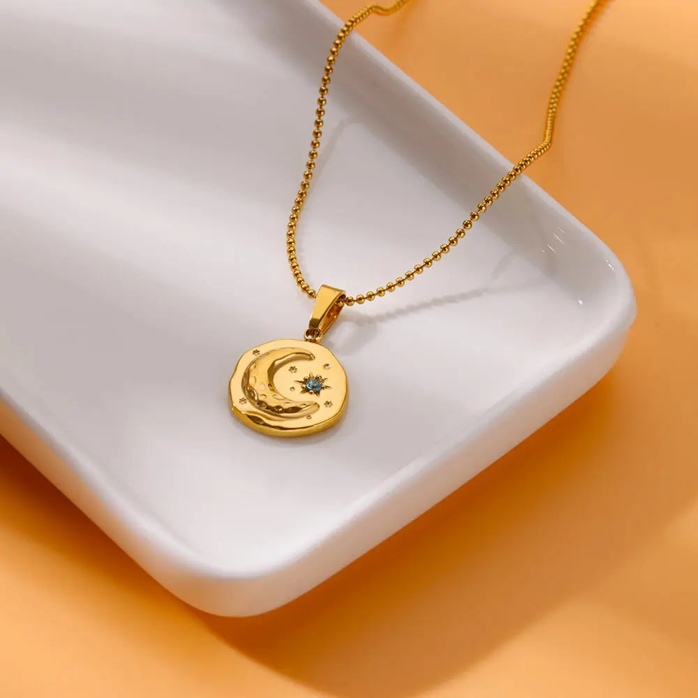 Collier avec pendentif croissant de lune et étoile sertie d'un zircon bleu