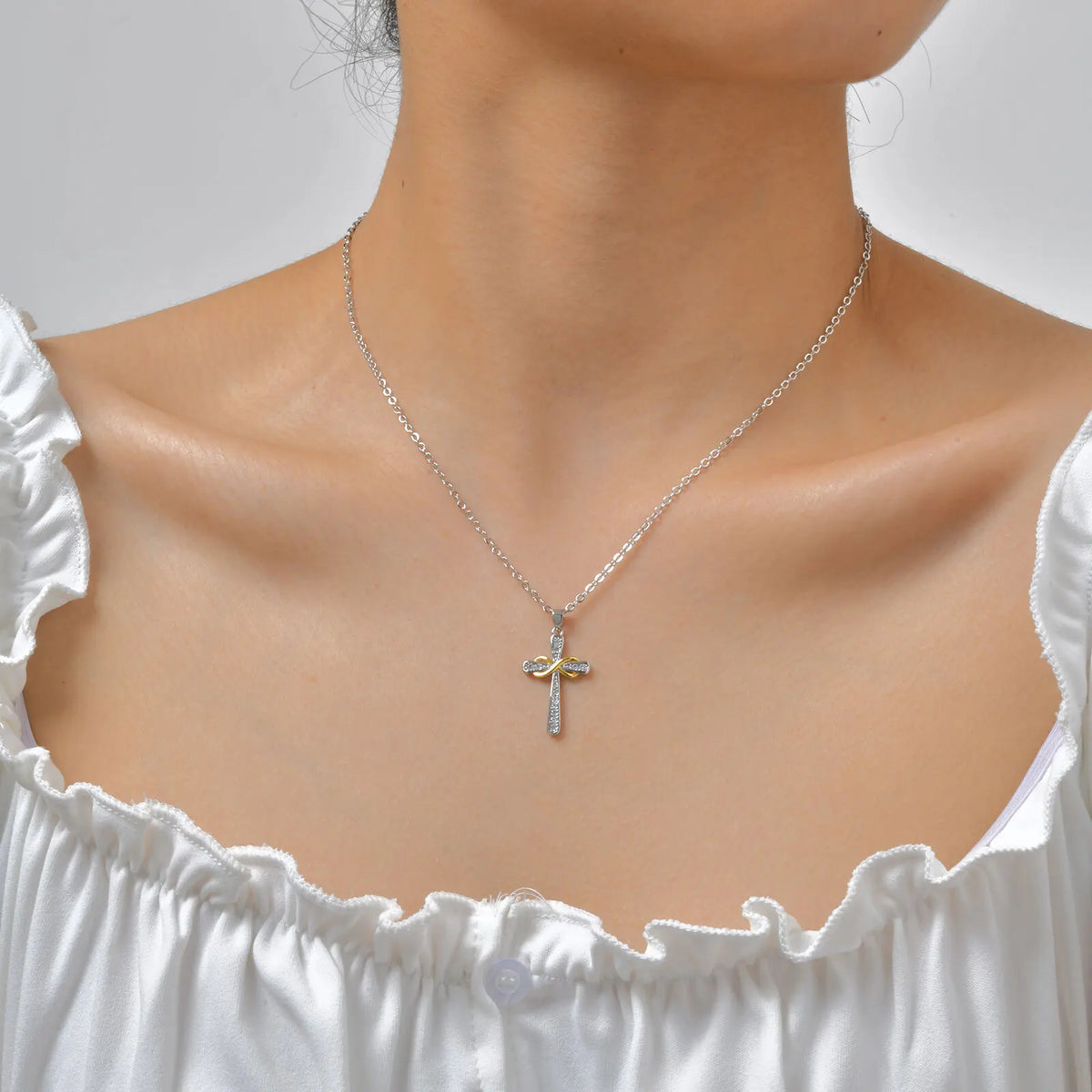 Collier avec pendentif croix et symbole infini bicolore