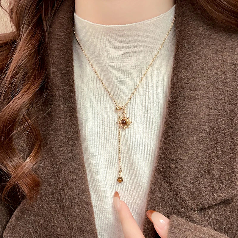 Collier cravate avec pendentifs astre solaire et pierres d'oeil de tigre