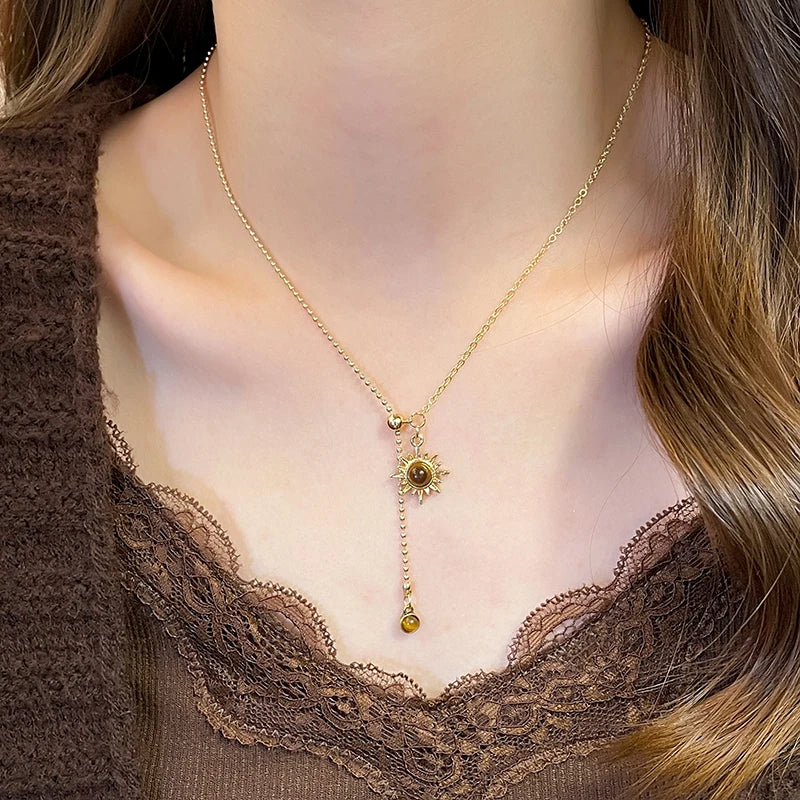 Collier cravate avec pendentifs astre solaire et pierres d'oeil de tigre