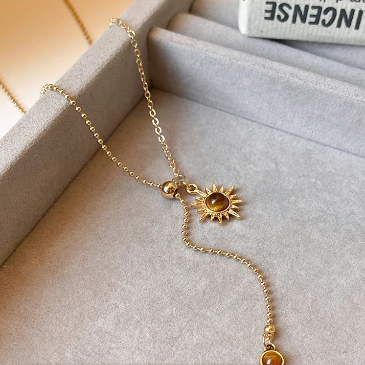 Collier cravate avec pendentifs astre solaire et pierres d'oeil de tigre