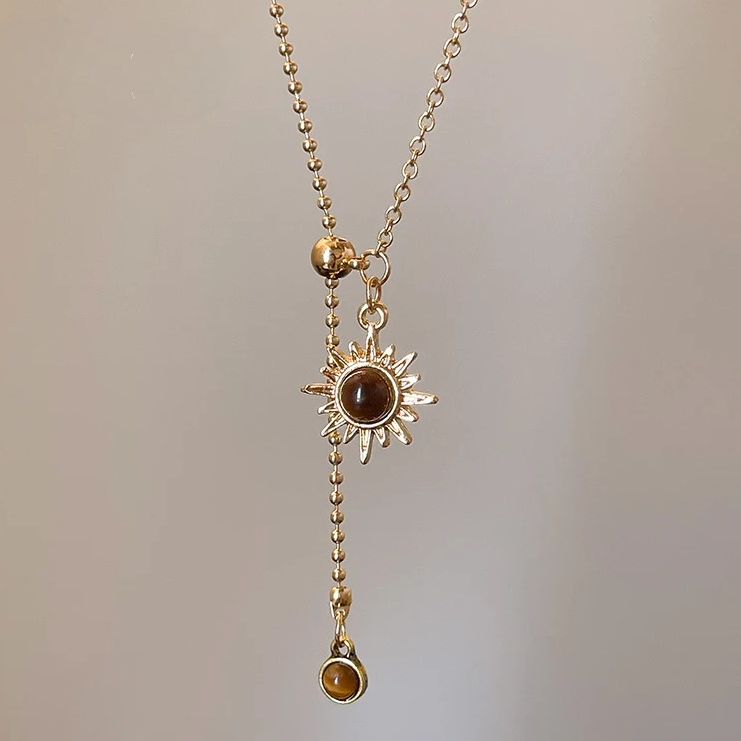 Goldene Krawattenkette mit Anhängern in Sonnenstern-Form und Tigeraugensteinen