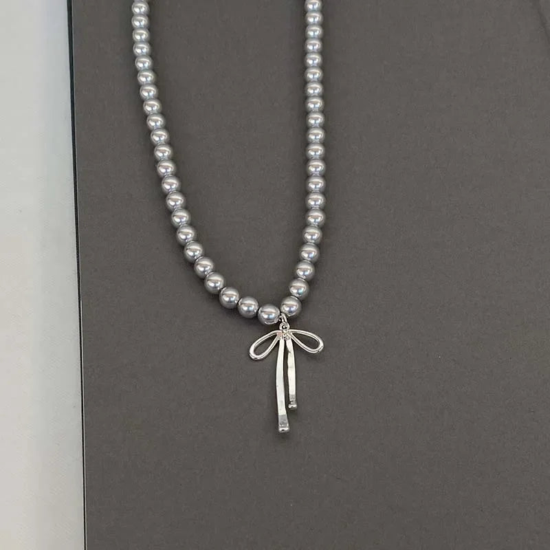 Collier Pendentif avec Perles Grises et Noeud de Papillon 