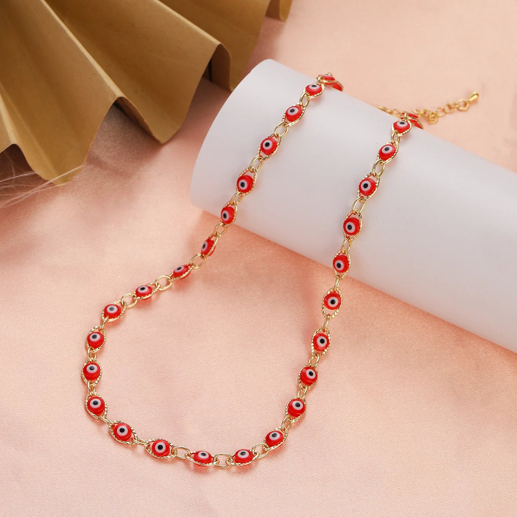 Collier ras de cou orné de multiples pendentifs oeil bleu rouge clair
